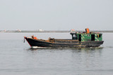 Small coastal vessel passing in front of Cat Hai Island