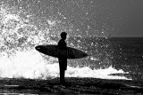 Surfer waiting with board in monochrome 