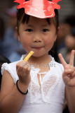 Little Vietnamese girl eating chip