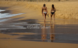 Bikini girls walk along North Curl Curl Beach