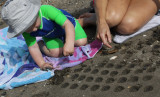 Mila helping Sam make sand patterns