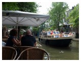 The lives in Utrecht, eat by the canal and watch the boat and people go by