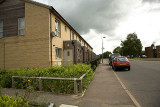Cars parked on the main road outside the last new build