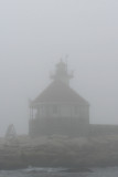 Tiny octagonal Cuckolds lighthouse in the fog.