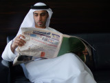 Reading the paper Dubai.jpg
