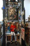 SARA SITS ON AN OUTHOUSE AT THE UNIVERSITY OF ALASKA MUSEUM EXHIBIT ON VINTAGE OUTHOUSES