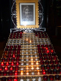 A cross design in candles with an image of Jesus in the background.