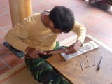 This young man is carving block prints. The Dong Ho style of painting and printing are 300 years old.