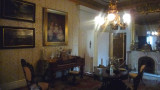 Ornate Central Parlor with a crystal chandelier, a piano and marble fireplace. The furniture is in this room is original.