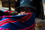 Child carried on the back wrapped in a blanket