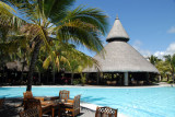 Shandrani Hotel pool with the thatched roof of one of the restaurants
