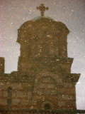Dome of Sveti Marko reflected in rain puddle