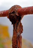 A rusty fence support
