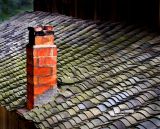 Late afternoon sun on a Kam chimney and clay tile roof.