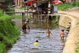 2625 Washing, bathing and playing in the village stream.