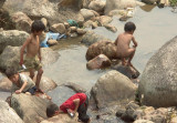 Four small  boys in a creek