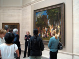 A docent discusses The Feast of the Gods.