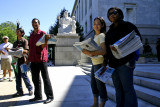 while they wait, some hand out newspapers telling of the struggles for immigrants rights