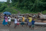 Villagers pass the abandoned Malaysian logging camp, Anuta