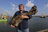 0119M-Visser Adrie Vonk met uit de Noordzee opgevist mammoetbot in de haven van Stellendam