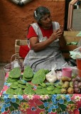 Selling prickly pear cactus leaves (spines removed) and fruit in the market