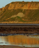 Evening sunlight brightens the cliffs and pools.