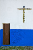 Blue wall, brown door, cross in white