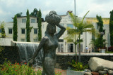 Close-up of the statue of a working woman carrying a bundle on her head.