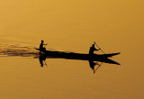 Two men in a pirogue crossing the Niger at sunset, Niamey