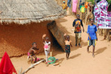 Excited village children rush out to watch our big red truck pass by