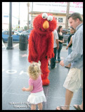 Elmo taking money from a little girl.