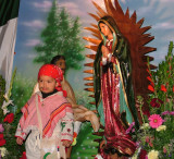 A little boy dress asJuan Diego poses for a photo with the Virgen de Guadalupe