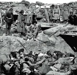 Russian soldiers stand above a trench of dead Japanese