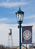 A bridge sign and streetlight with water tower in background