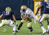 Yellow Jackets B-back Sims covers the ball in anticipation of a hit by Pitt DB Vinopal