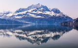 Calm waters reflect a mountain range in Glacier Bay National Park