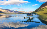 A pontoon plane taxies to the beach at Twin Lakes in Lake Clark National Park