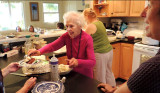 March 2013 - Mom serving out portions of her 92nd birthday cake to guests at her party at Wendy and Jims