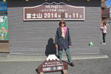 Judy at a sign at the Fuji Subaru Line 5th Station showing we are more than halfway up the side of Mt. Fuji 