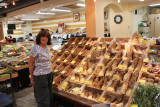 Judy near a vegetable stall featuring cone-shaped Takenoko (bamboo) at the indoor Omi-cho Market in Kanazawa