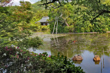 Three turtles on a small rock and the Bentenjima Islet in the Kyoyochi Pond at the Ryoanji Temple in Kyoto