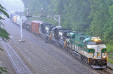 SR 8099 leads train 197 through the crossover at Revilo during a strong summer storm
