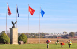 The flags of a veterans memorial fly high as NKP 765 passes in the distance at New Waverly