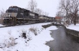 Train 224 follows a frozen Town Branch creek through Harrodsburg with a SD70m and a BNSF possum on the point 
