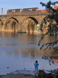 Mr. Odell shoots from the riverbank as a Eastbound train starts out on the bridge just before dark 