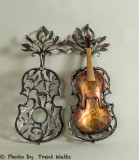 An old violin encased in a metal cage ready for a Symphony fundraiser.