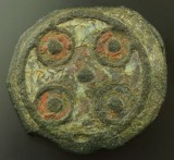 Anglo Saxon enamelled disc brooch in champlev, 9th Century, with a green cross defined by the four red circles. Norfolk.