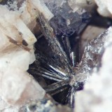 Allanite crystals (4 mm across) with fluorite, Pigeon Rock Mountain, Mourne Mountains