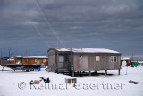 Dark clouds over wood houses at dawn in the Eskimo village of Kaktovik Alaska on the Beaufort Sea