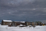 Dark clouds over storage sheds and houses in the Eskimo village of Kaktovik Alaska on the Beaufort Sea